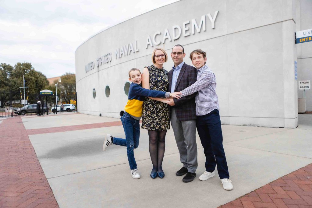 A family posing for a portrait in front of a building in downtown Annapolis.