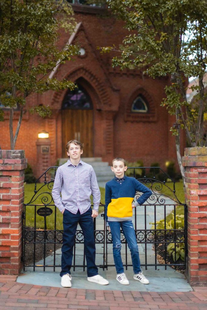 Two boys standing in front of a brick church in Downtown Annapolis.