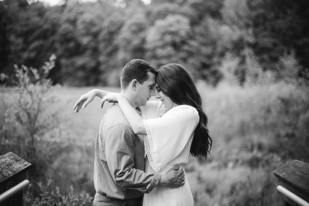 A black and white photo of a couple embracing in Patuxent Research Refuge.