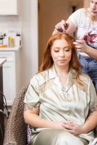 A woman getting her hair done in preparation for her wedding.