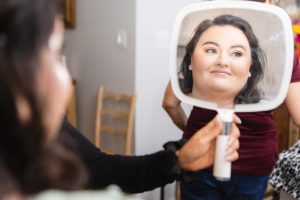 A woman is getting her makeup done in preparation for her wedding.
