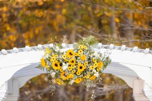 Wedding arch adorned with sunflowers and daisies, showcasing intricate details.