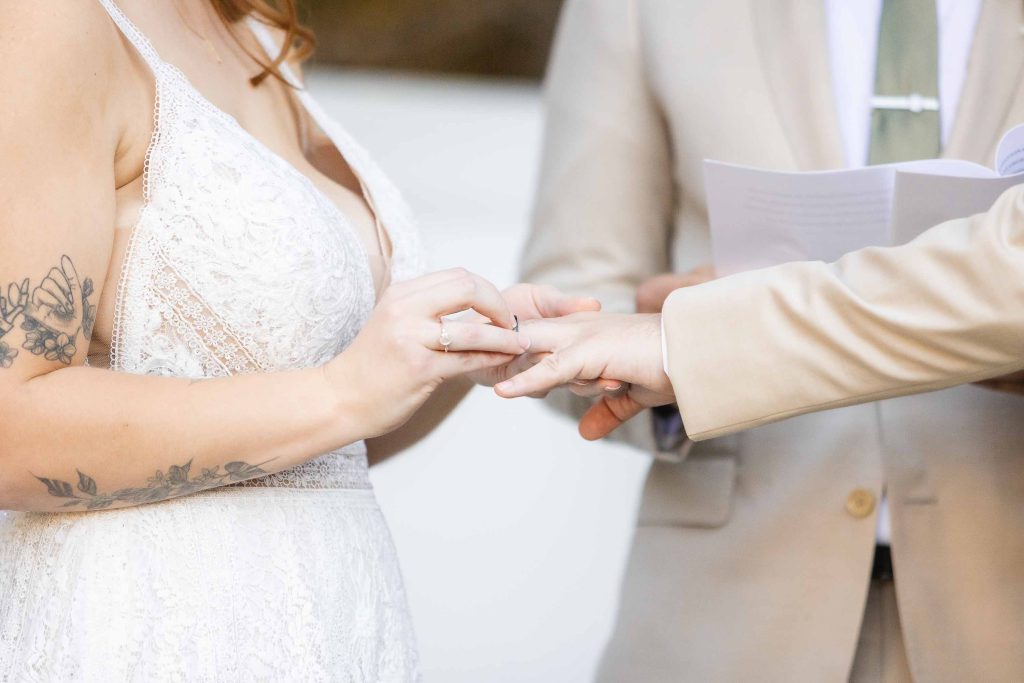 At the Wedding ceremony, the bride and groom joyfully exchange rings at the Blackwall Barn & Lodge.
