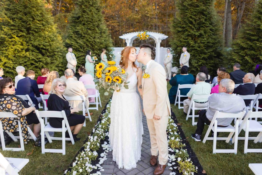 A bride and groom kiss during their outdoor wedding ceremony at the Blackwall Barn & Lodge.