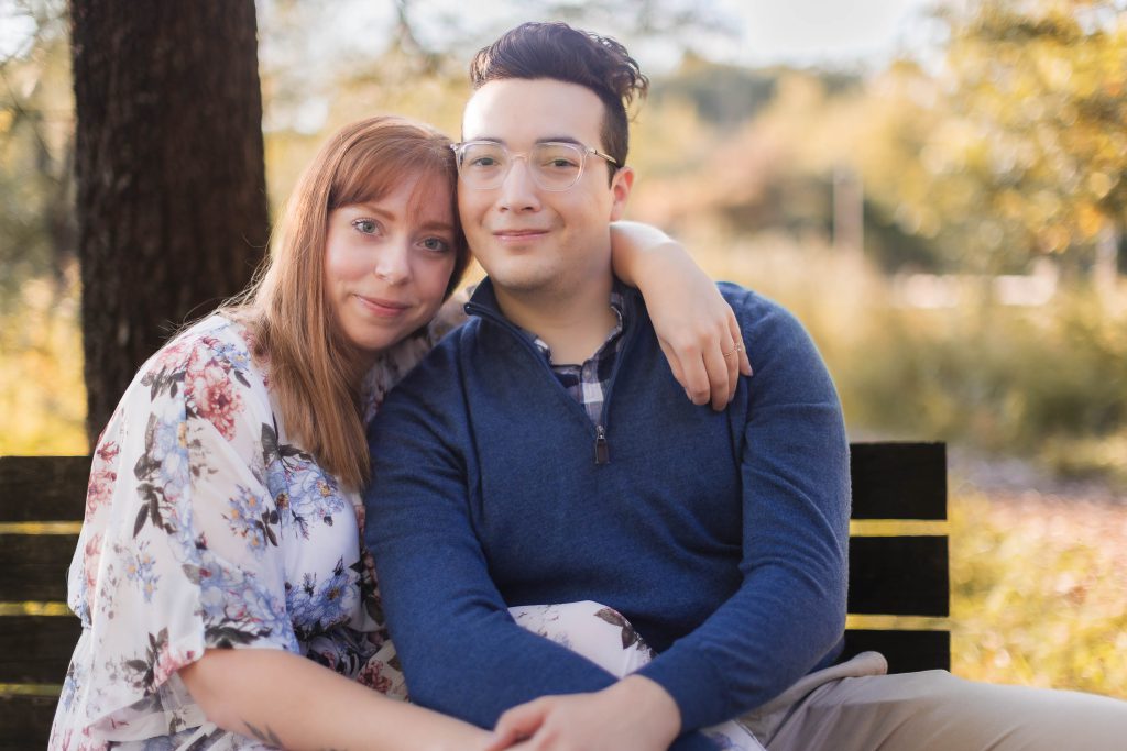 A couple sitting on a bench in Patuxent Research Refuge, capturing beautiful portraits during their engagement.