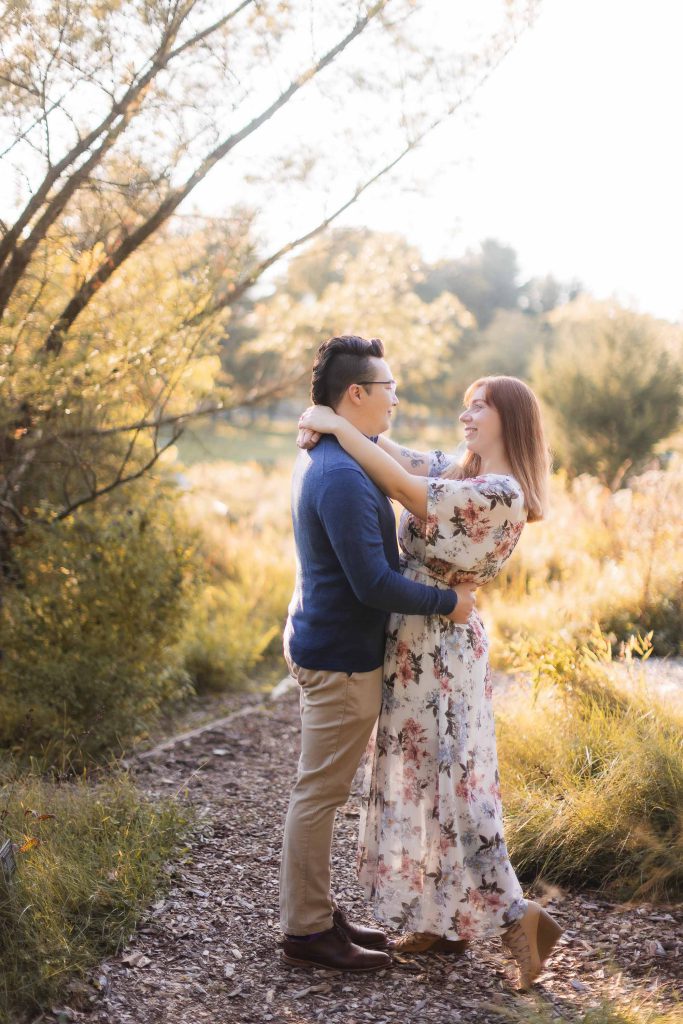 A couple embraces in the woods during their engagement session at Patuxent Research Refuge.