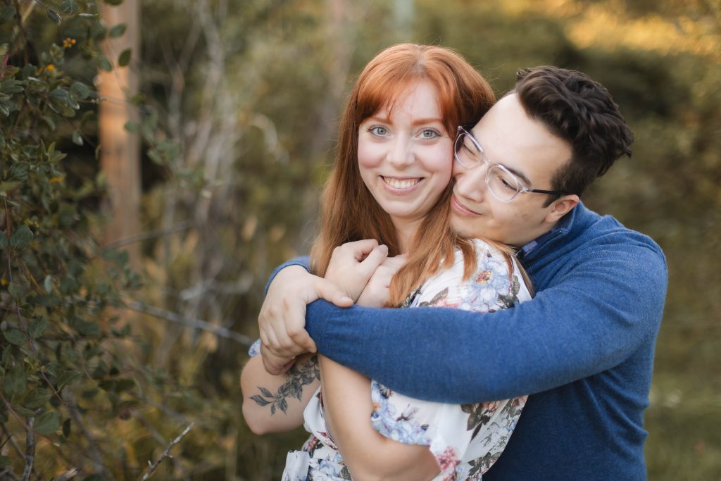 A couple hugging in the woods during their engagement session at Patuxent Research Refuge, capturing beautiful portraits.