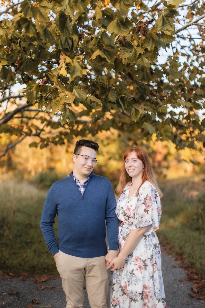 A couple standing under a tree during their engagement session at Patuxent Research Refuge.