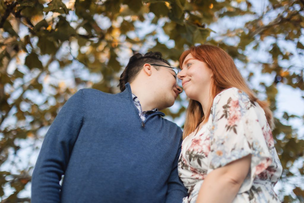 A couple poses for enchanting engagement portraits under a tree at Patuxent Research Refuge.