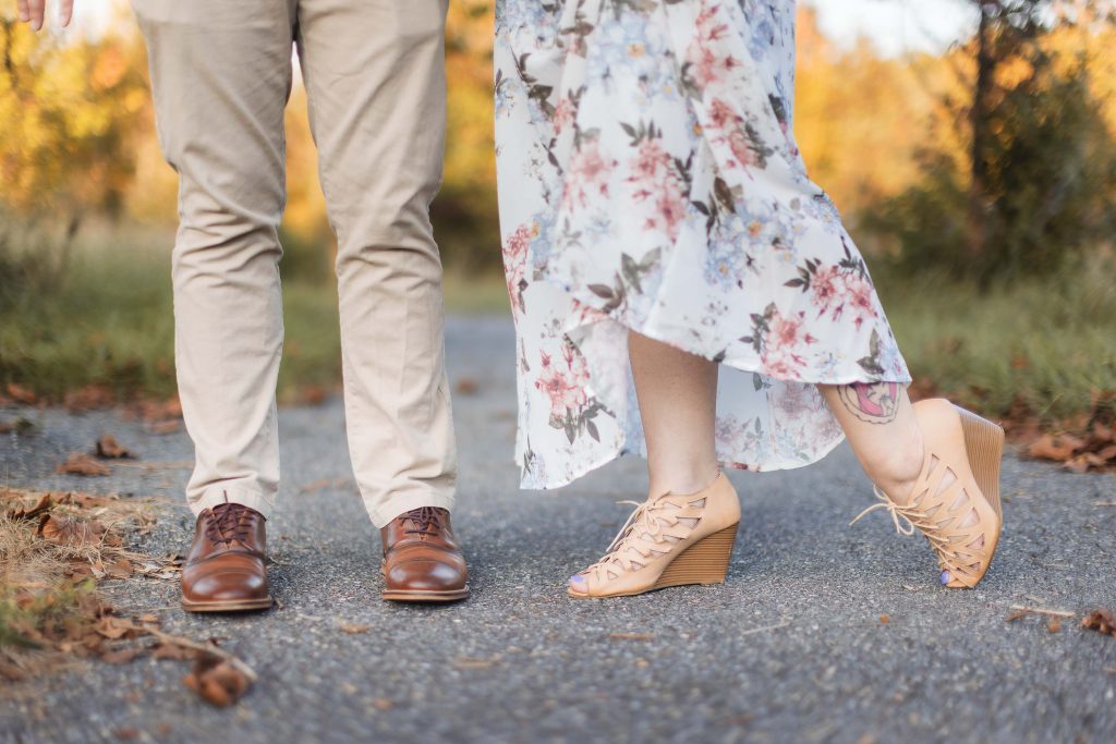 A couple standing on a path at Patuxent Research Refuge, their feet together, capturing engagement portraits.