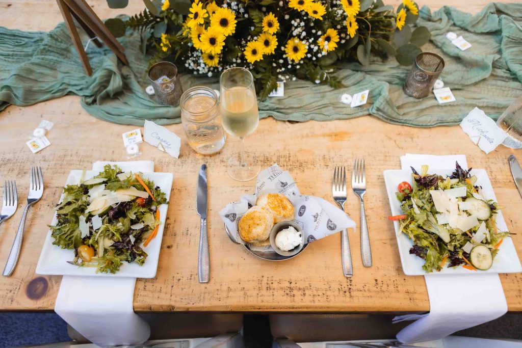 A wooden table adorned with sunflowers, perfect for adding rustic details to a wedding setting.
