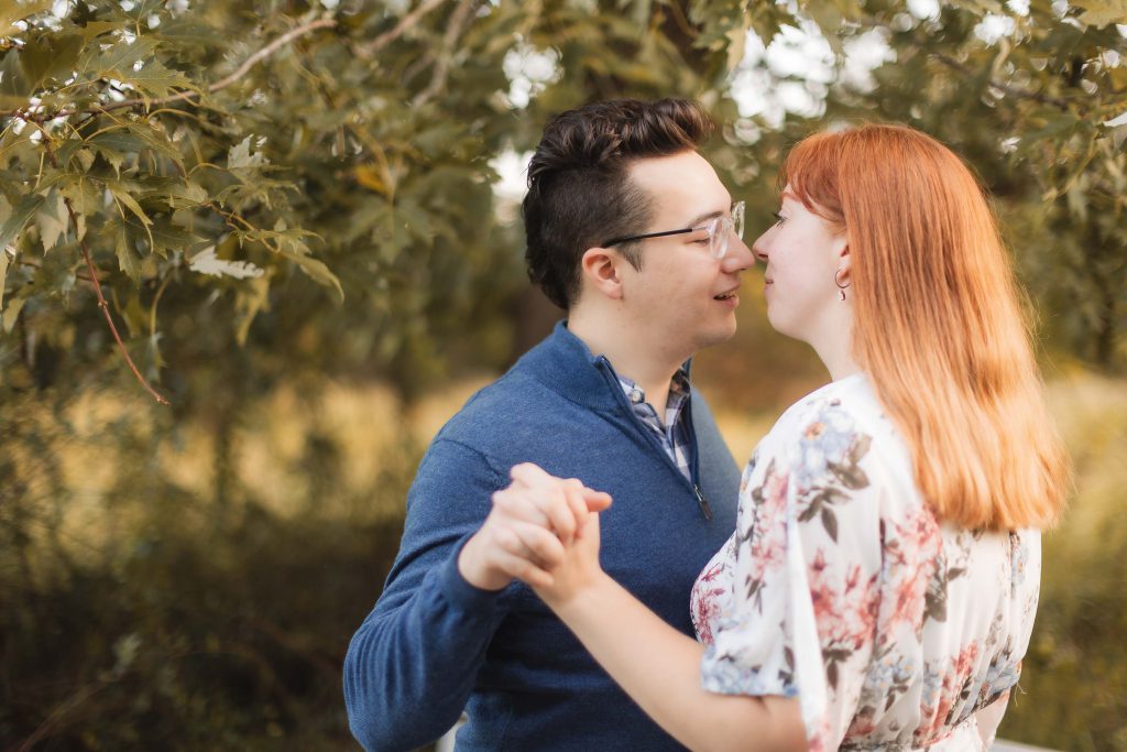 A couple kissing under a tree during their engagement session at Patuxent Research Refuge.