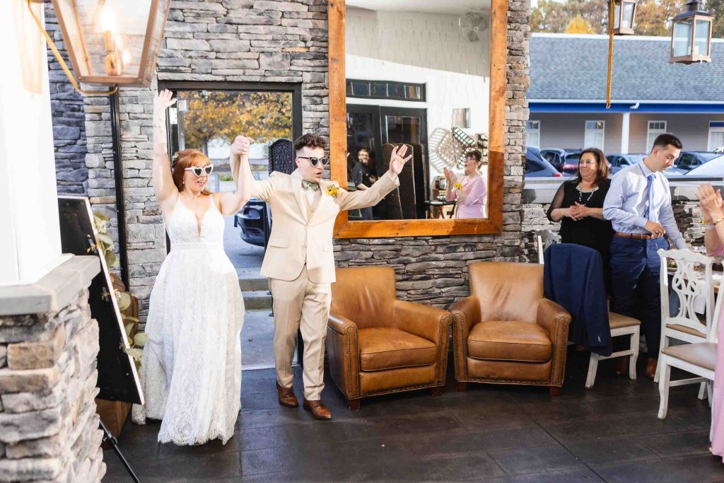 At their wedding reception at Blackwell Barn & Lodge, the newly married bride and groom share a sweet moment as they happily wave to each other in front of the restaurant.