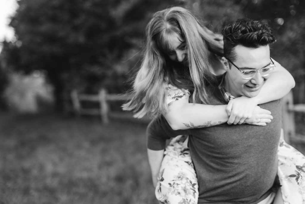Black and white photo of a man carrying a woman in a field at Patuxent Research Refuge.