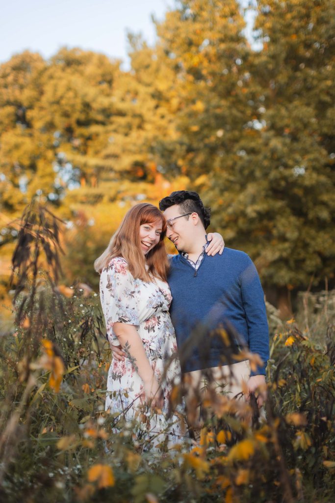 A couple embracing in a field of wildflowers during their engagement session at Patuxent Research Refuge.
