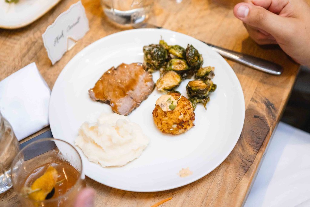 A white plate with wedding food and drinks on it, showcasing intricate details.