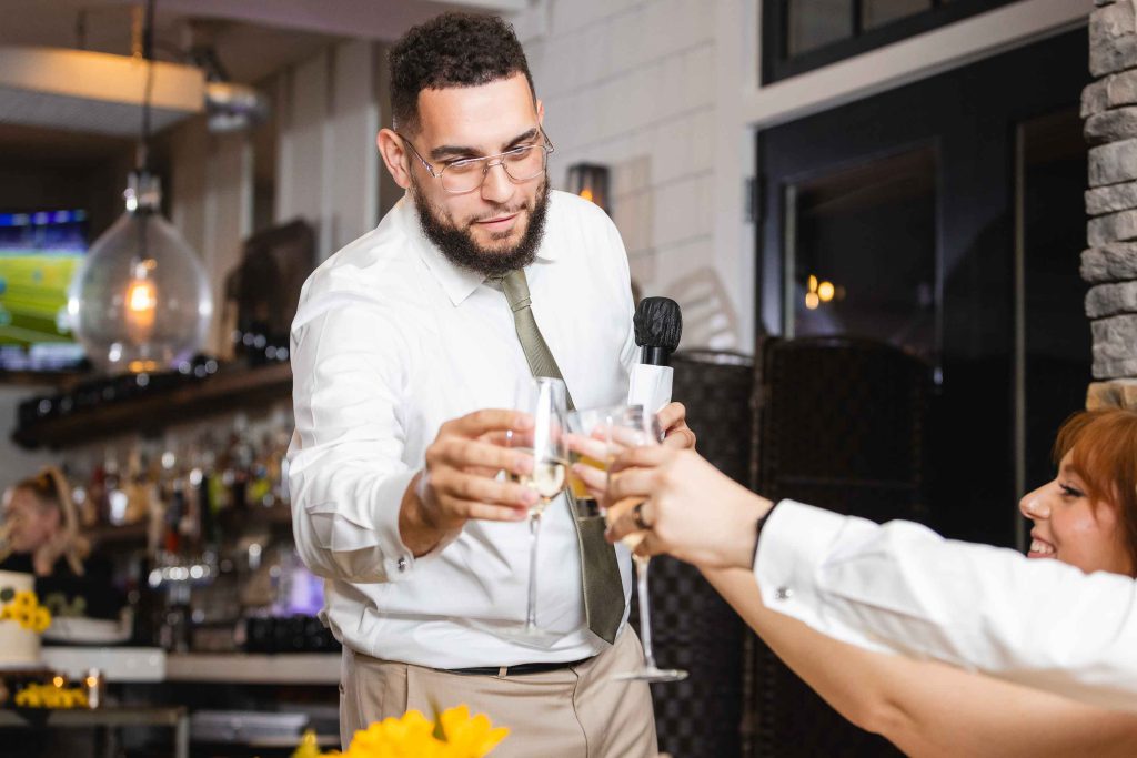 At a wedding reception at the Blackwall Barn & Lodge, a man is giving a toast to a group of people.