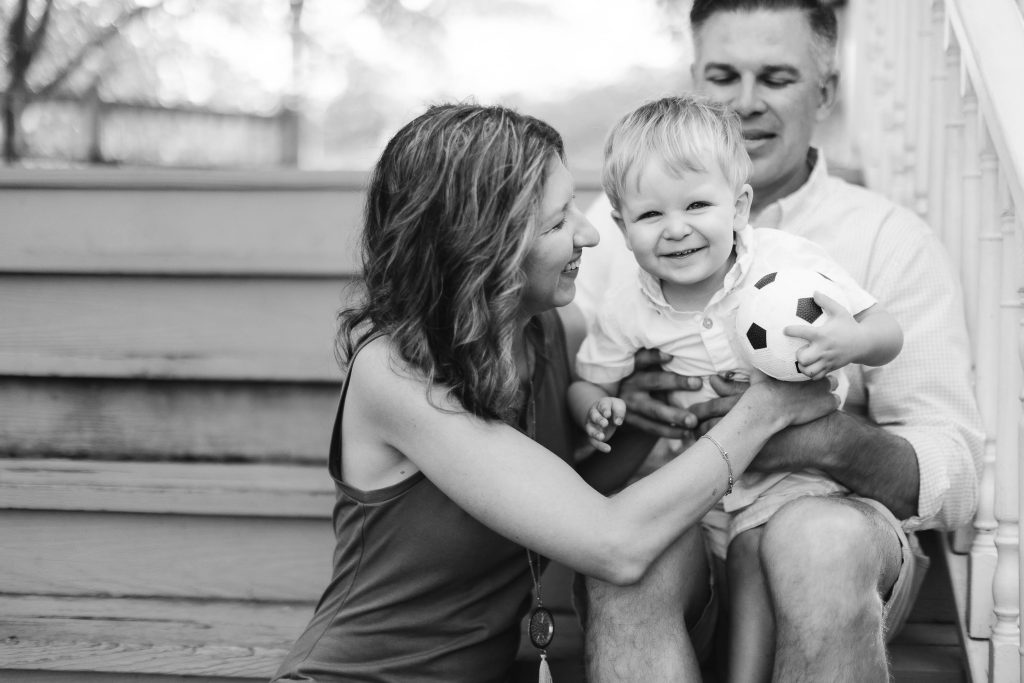 A black and white portrait of a family sitting on steps at Quiet Waters Park in Annapolis.