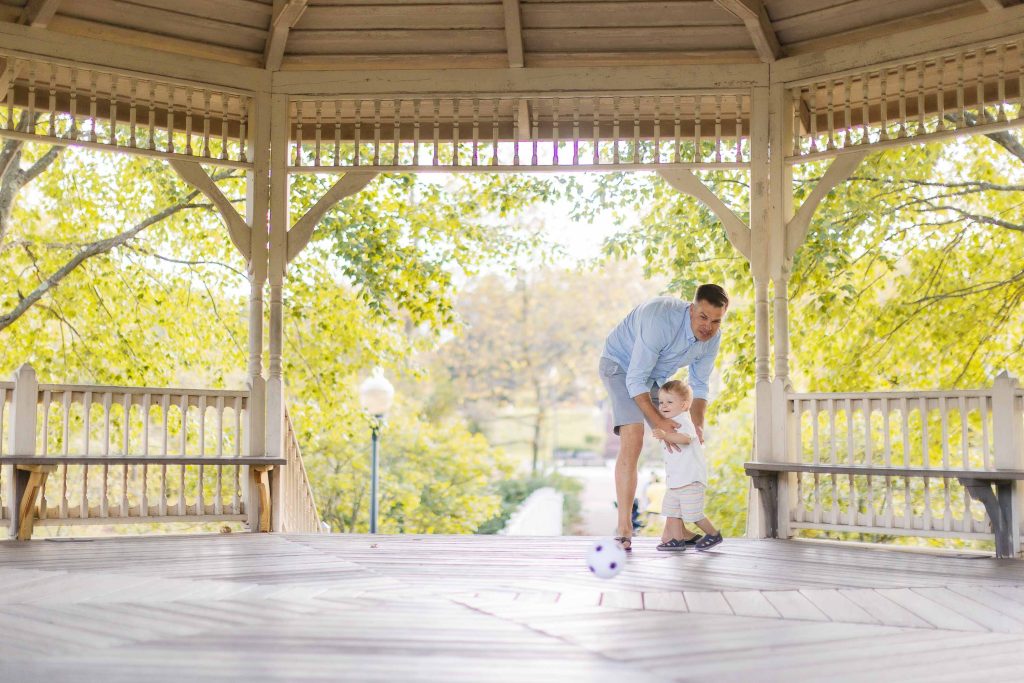 A man and a child standing on a gazebo in Quiet Waters Park in Annapolis for portraits.