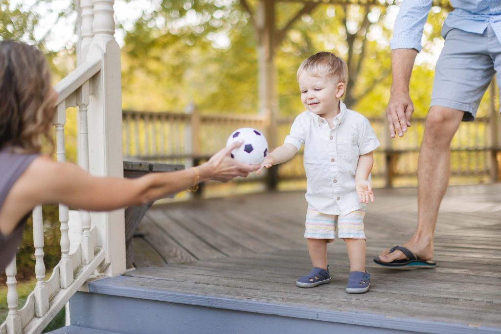 A young boy is playing with a soccer ball on a porch in Annapolis.