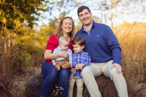 A family is posing for a family photo at Quiet Waters Park.