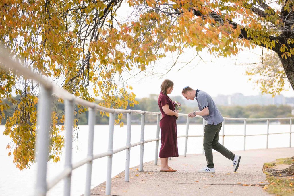 A couple kissing on a bridge near the Tidal Basin in Washington DC.