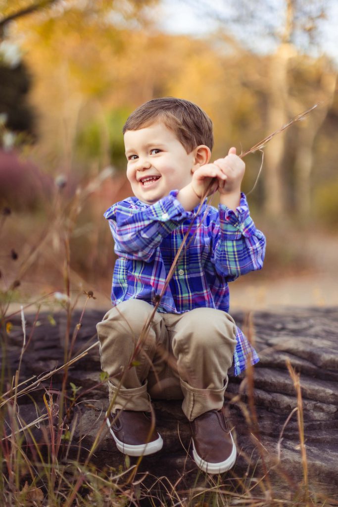 A young boy sitting on a log in Quiet Waters Park, Annapolis Maryland.