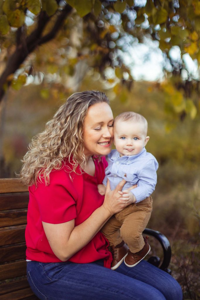 A woman holding a baby on a bench at Quiet Waters Park in Annapolis, Maryland.