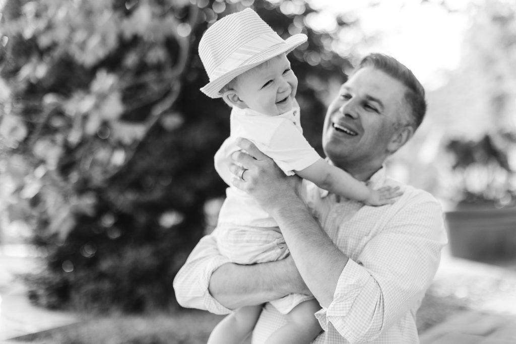 In this black and white portrait, a man tenderly holds a baby, capturing the essence of family bonds.