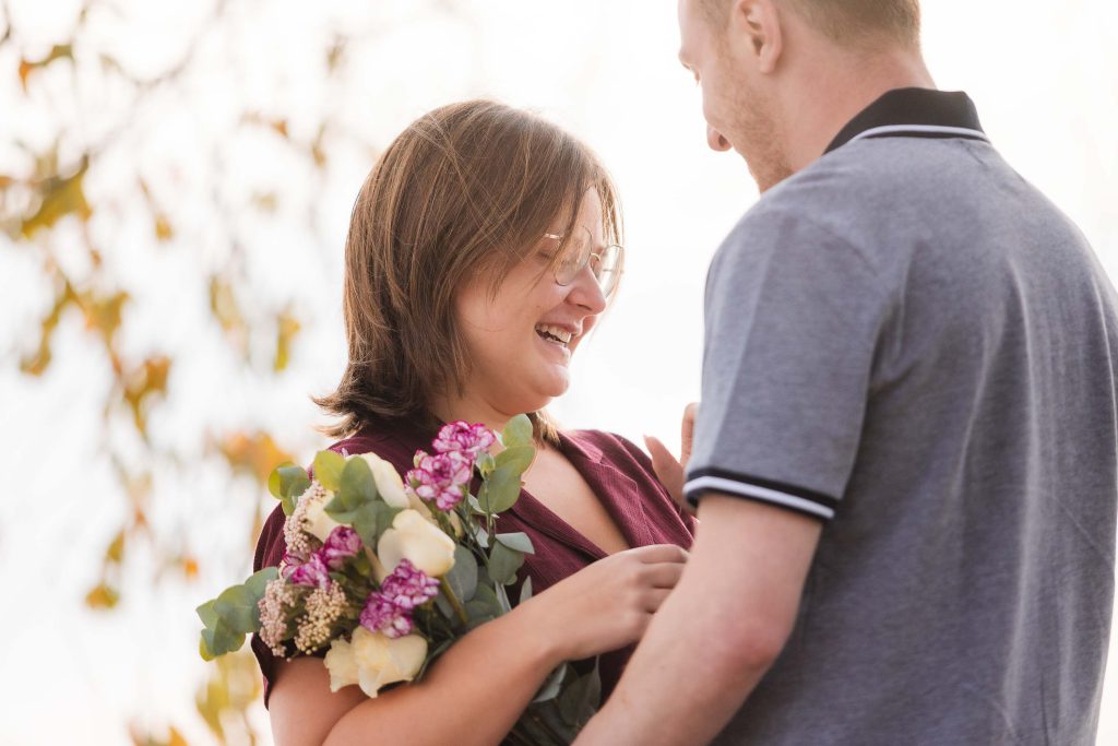 In Washington DC, a man surprises a woman with a bouquet of flowers during a wedding proposal.