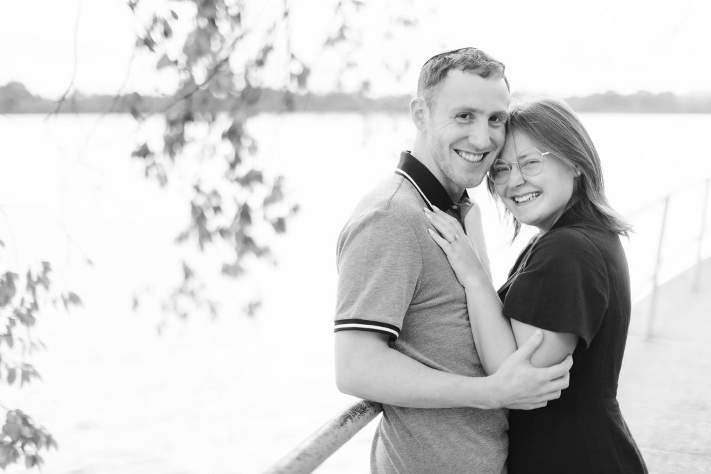 A black and white photo of a couple embracing near the water in Washington DC.
