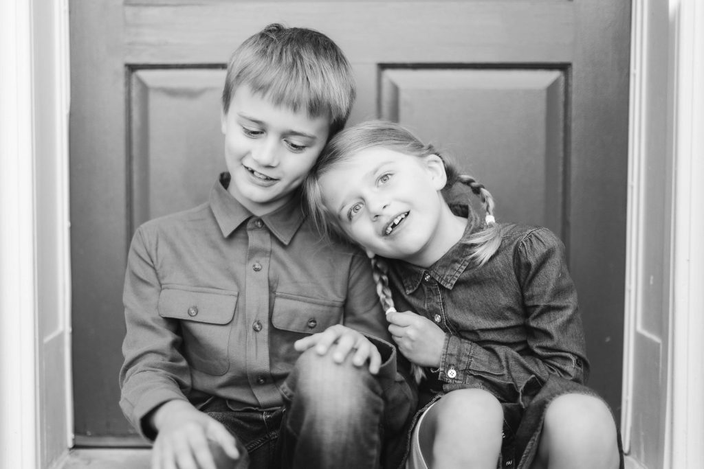 A black and white photo of a boy and girl sitting on the steps in Belair Mansion, Bowie Maryland.