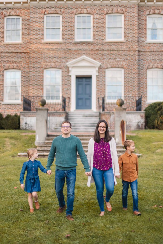 A Family walks in front of Belair Mansion.