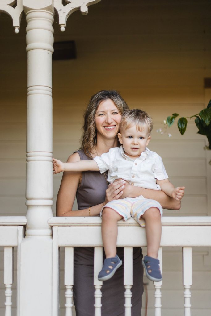 A woman and her son standing on the porch of a house in Annapolis, quietly capturing memorable portraits at Quiet Waters Park.
