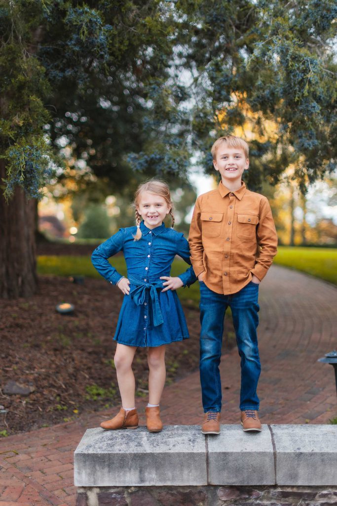 Two children from a Family standing on a brick wall in Belair Mansion, Bowie Maryland.