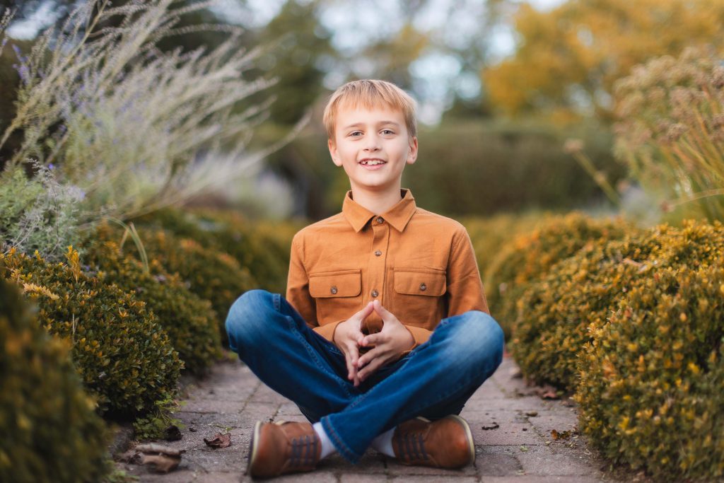 A young boy sitting in a garden at Belair Mansion.