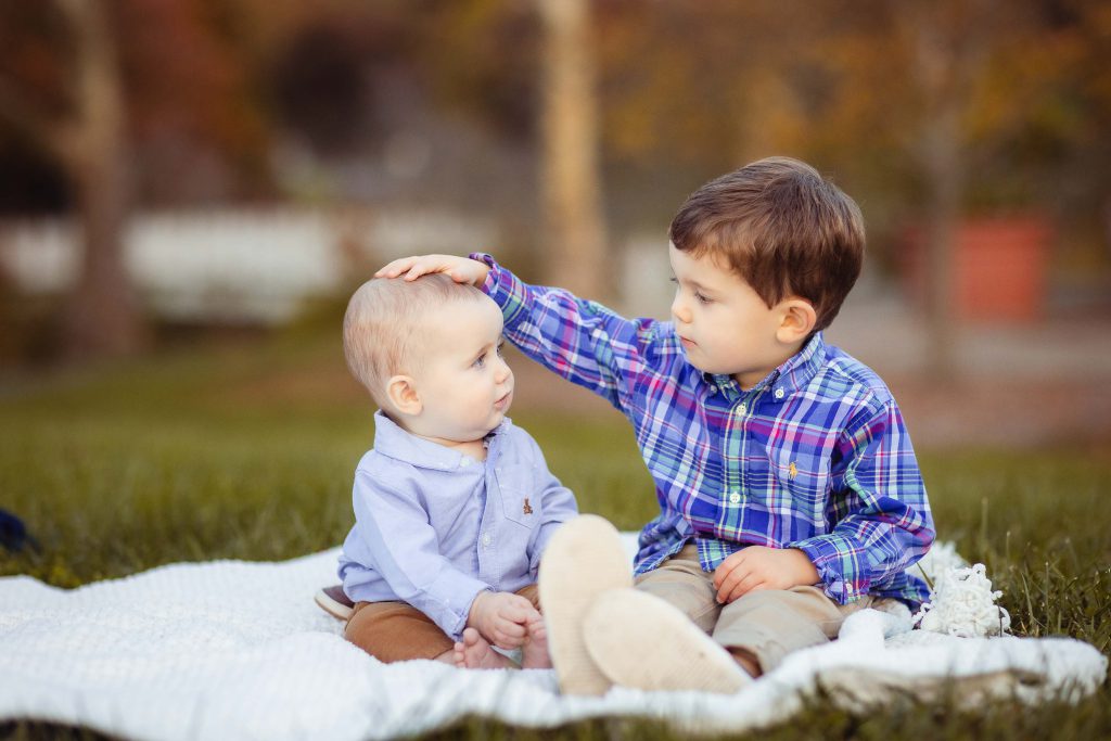 Two boys sitting on a blanket in a park in Annapolis Maryland.