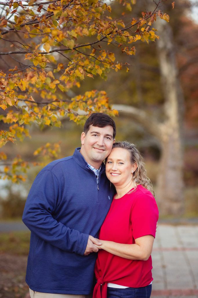 A family posing in front of a tree in Quiet Waters Park.