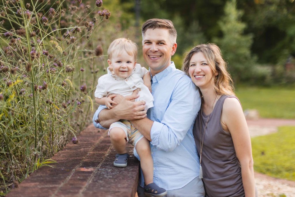 A family poses for a photo in Quiet Waters Park for their portraits.
