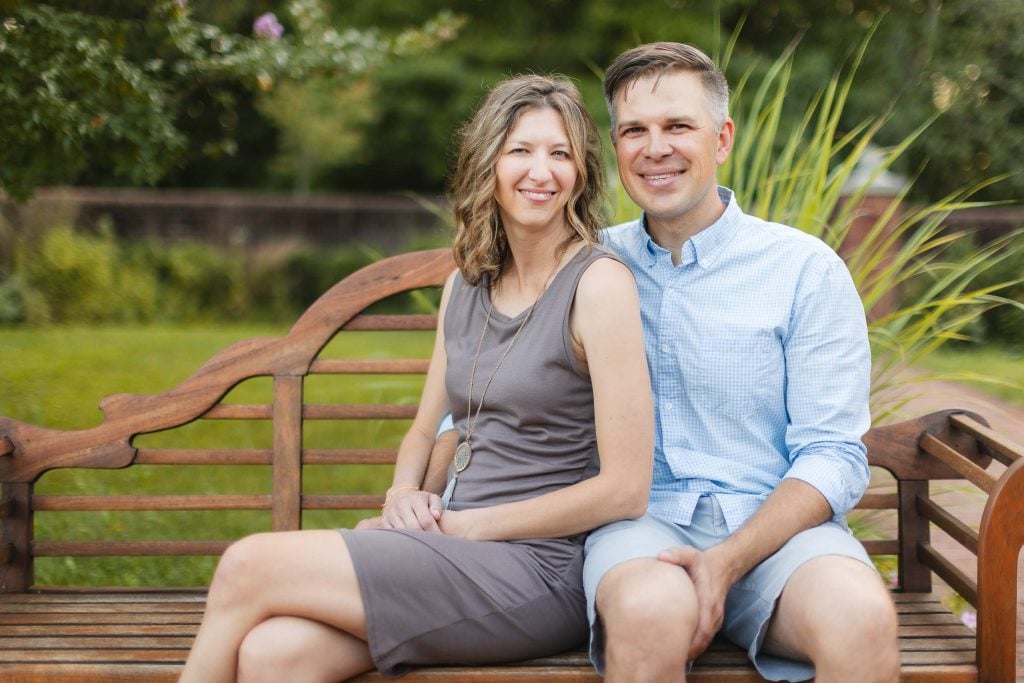 A family sitting on a wooden bench in Quiet Waters Park.