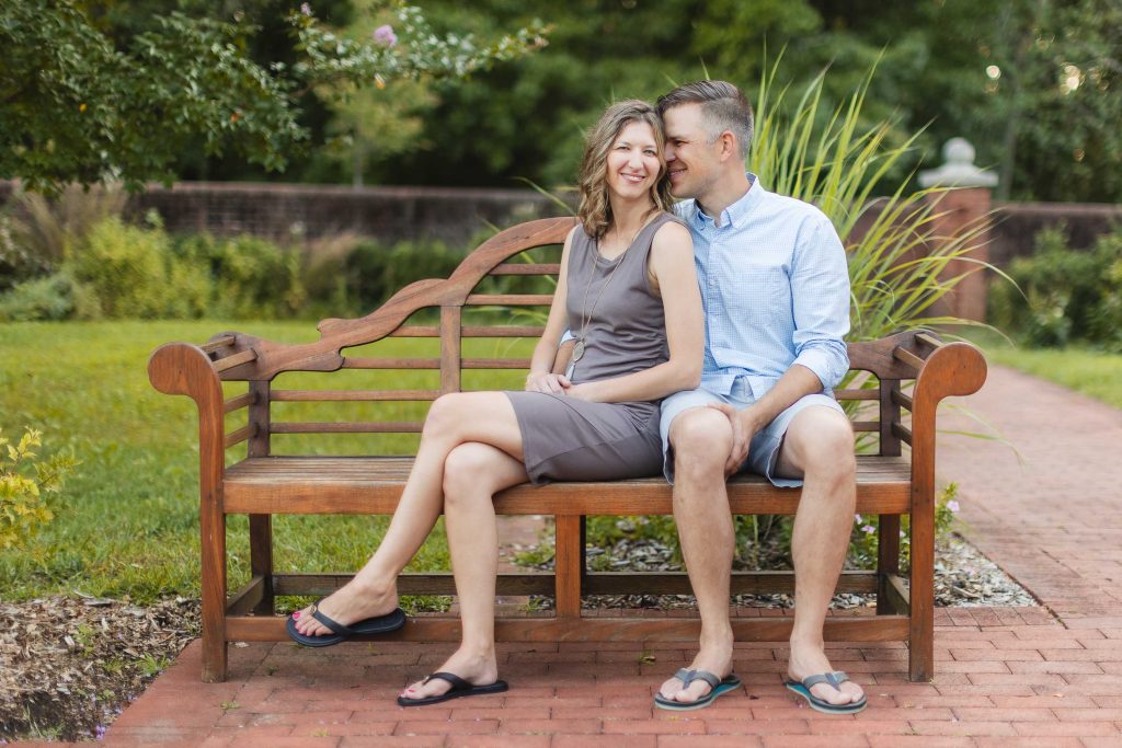 A couple sits on a wooden bench in Quiet Waters Park, Annapolis, creating beautiful portraits.