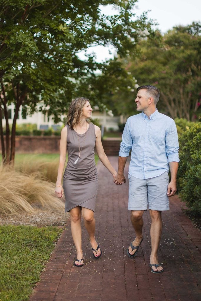 An engaged couple holding hands at Quiet Waters Park in Annapolis.