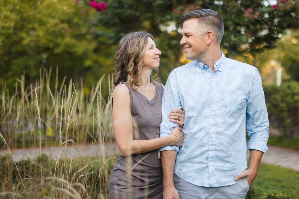 An engaged couple posing for romantic portraits in a field with tall grasses at Quiet Waters Park near Annapolis.