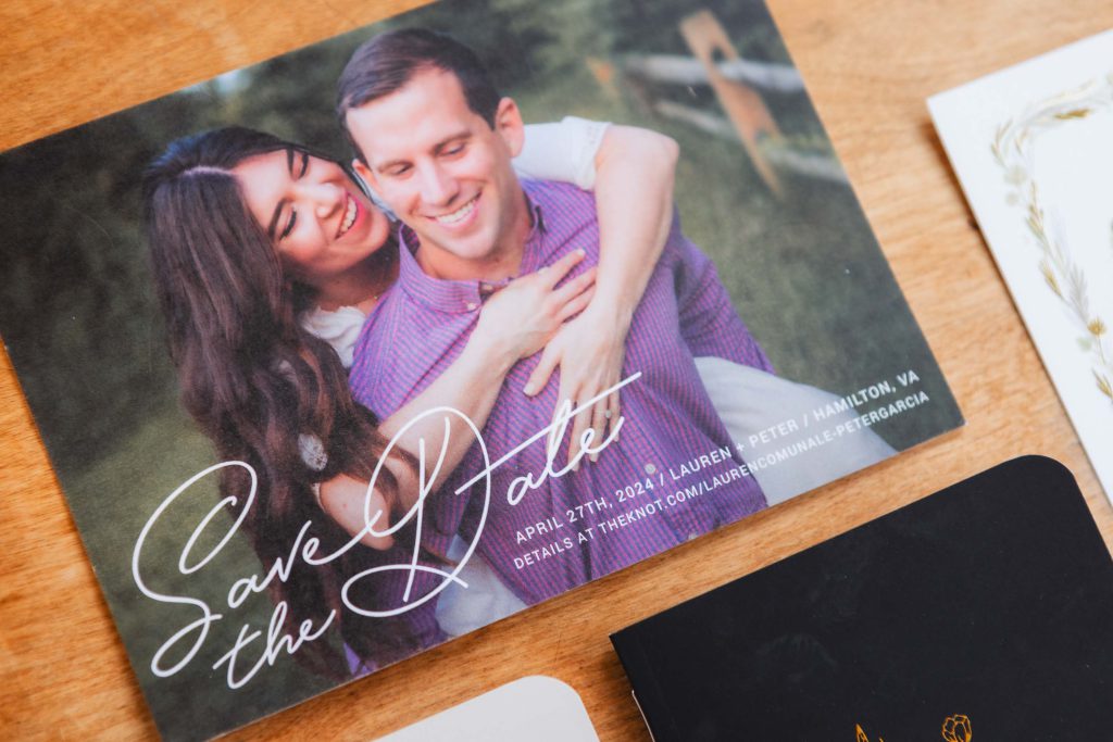 Save the Date card with a couple embracing, announcing their wedding date of April 27th, 2024, at The Barns at Hamilton Station. For full details, visit theherndon.com/lauren.