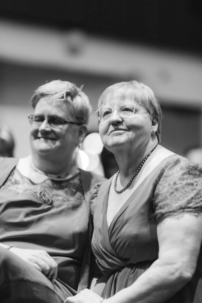 Two women smiling together at the National Aquarium in Baltimore, capturing a joyful moment at a beautiful wedding.